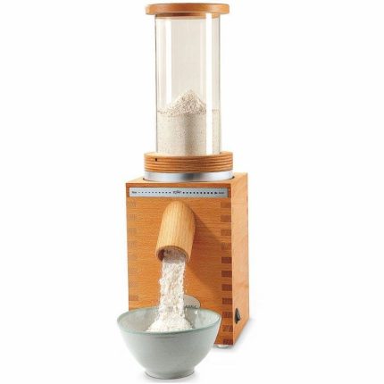 Flour sifter fitted to a stone grain mill, sifted flour falling into a bowl