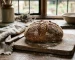 A rustic round wholemeal loaf made with fresh-milled flour on a wooden board